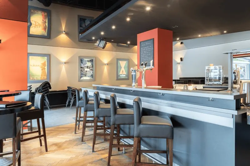 Bar in Olten mit Theke, Barhockern und roten Wänden