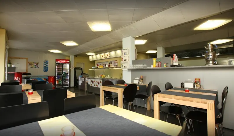 Gastraum des Foodpoint 13 in Emmenbrücke mit Holztischen und Theke